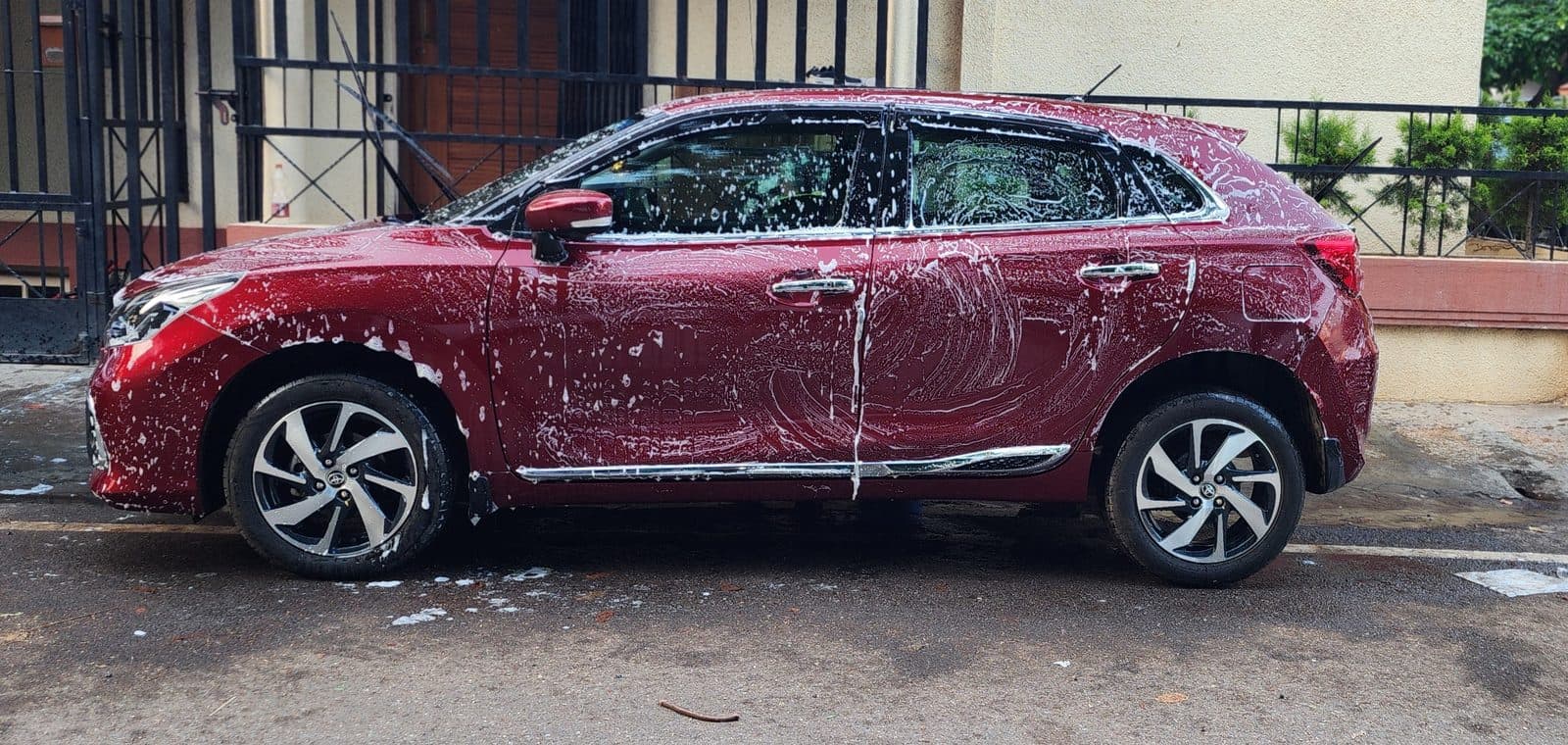 Shampoo wash in progress on a red SUV